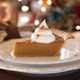Slice of pumpkin pie on ornate holiday table